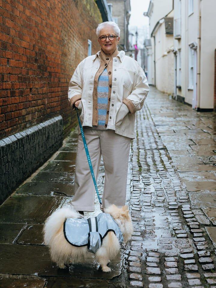 a woman standing on a brick wall wearing a denim jacket